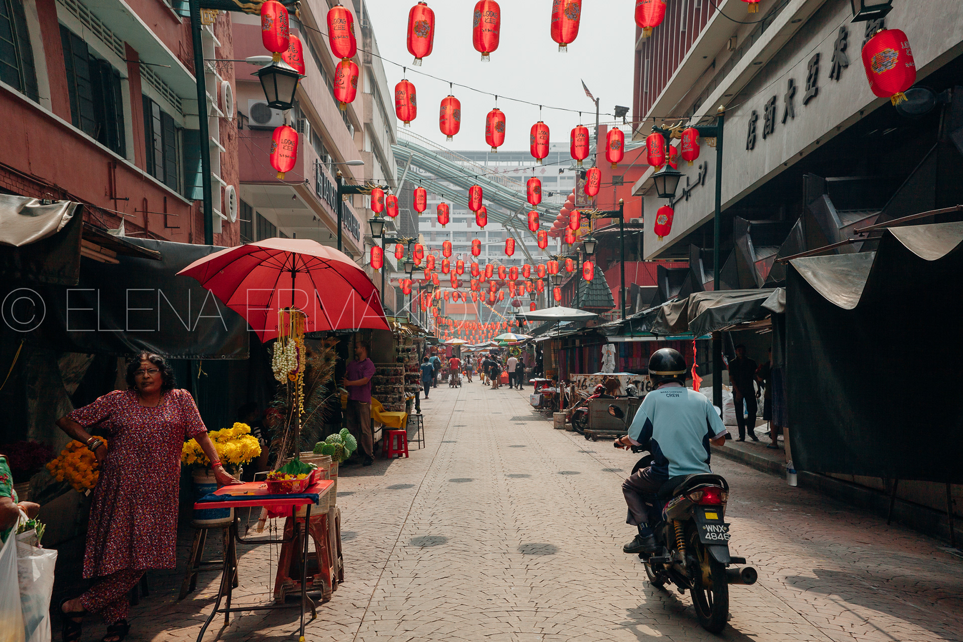 Man riding motorbike through the crowded Petaling street, Chinatown, Kuala Lumpur, Malaysia