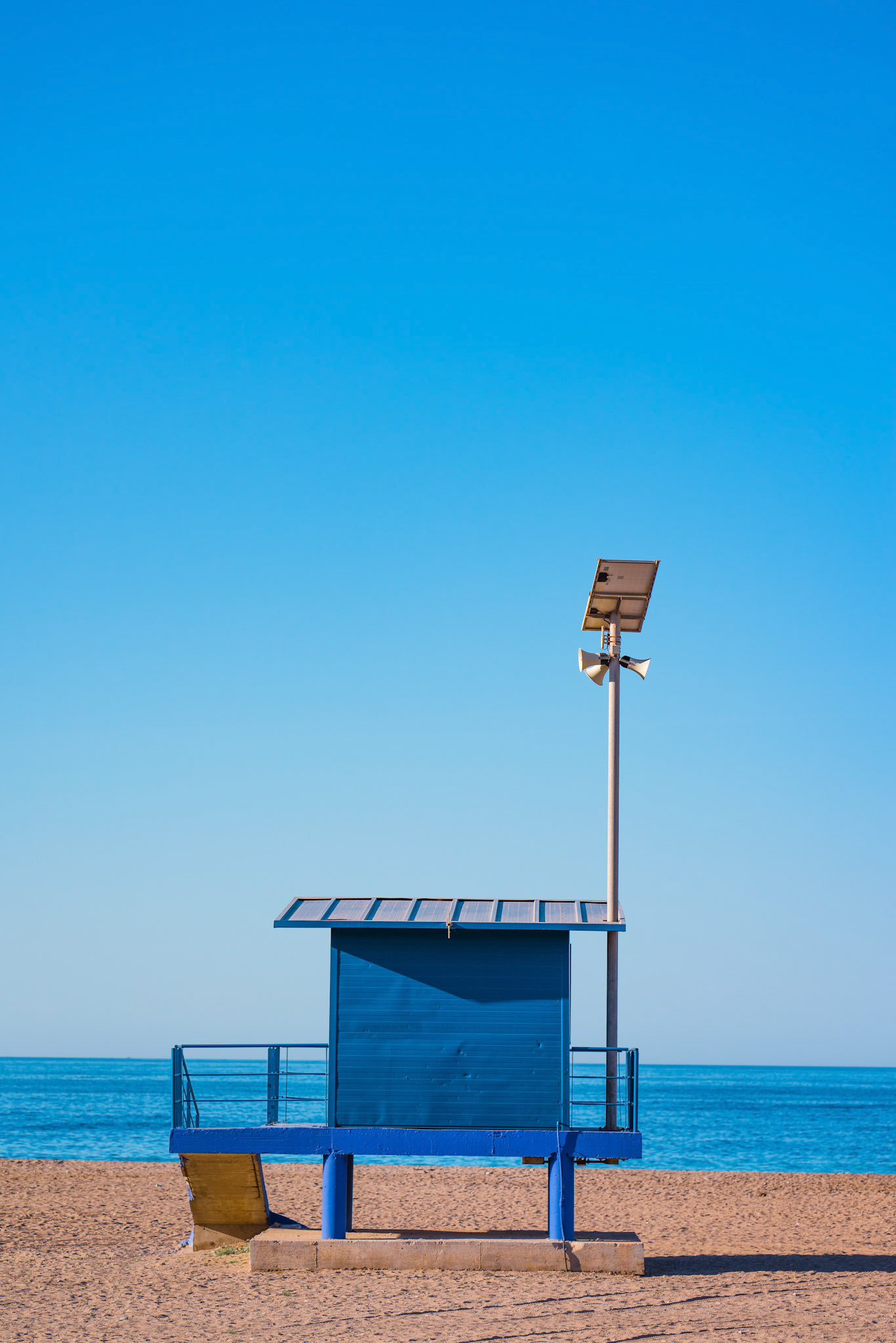 Mediterranean beach with blue vintage and lonely lifeguard wooden tower and speaker