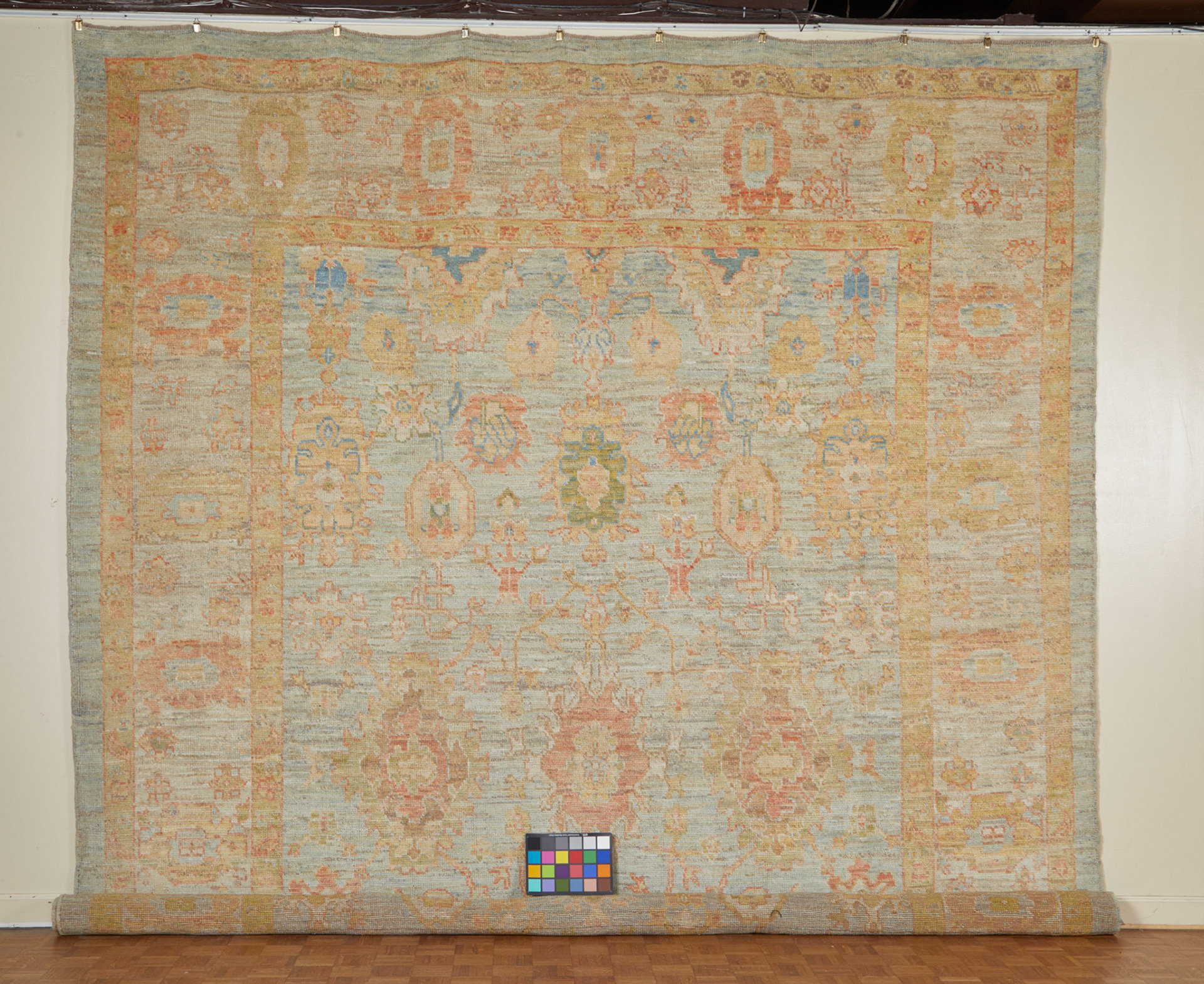 Original photo of Oushak Rug hung on wall