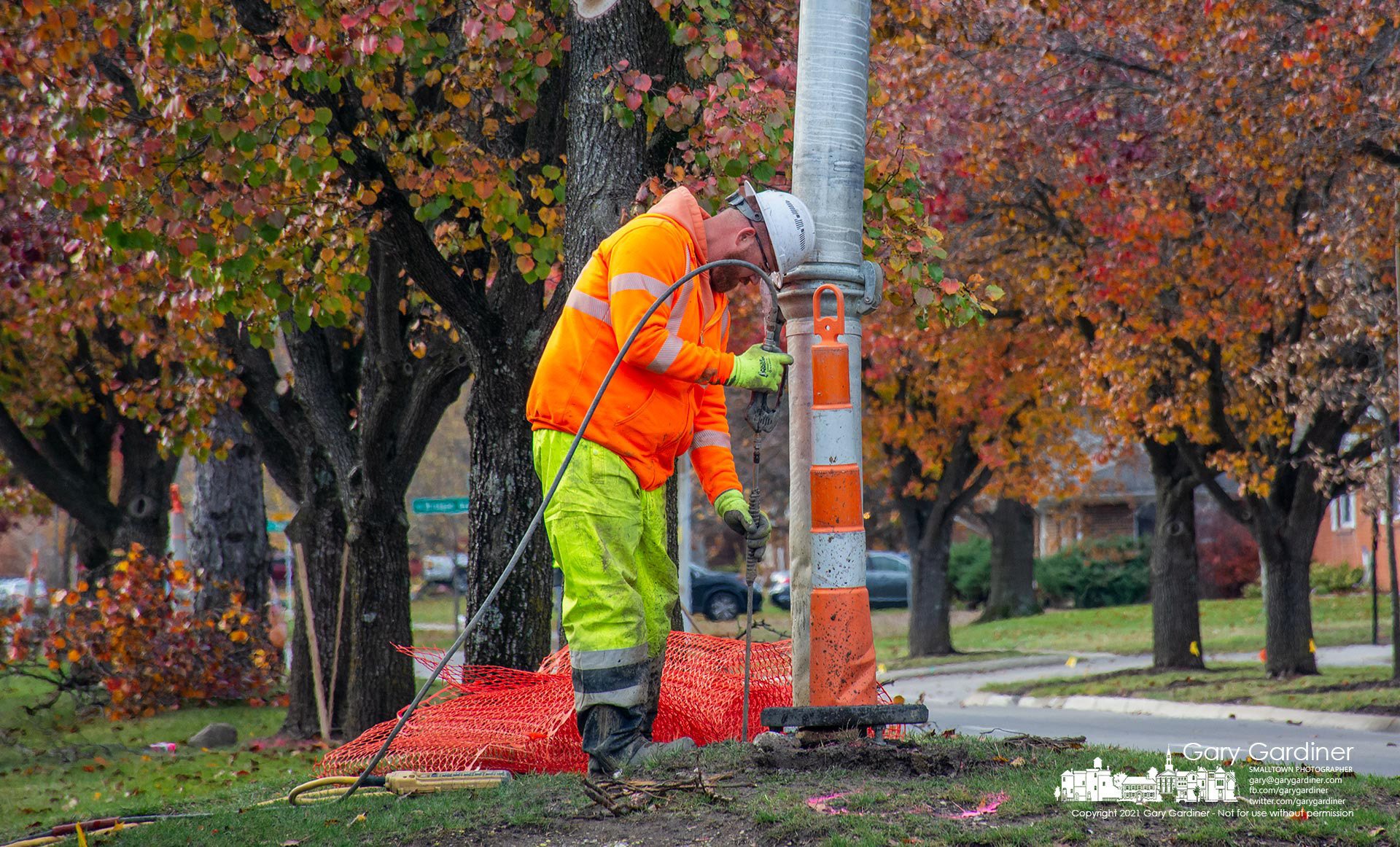 A worker uses water sprayed at 4,000 psi to clear away dirt and stocks where the city plans new street lights on Huber Village Blvd. My Final Photo for Nov. 18, 2021.