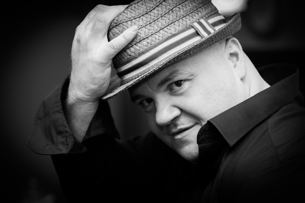 Jason Wilkinson Photographer posing for a profile photograph in a straw hat