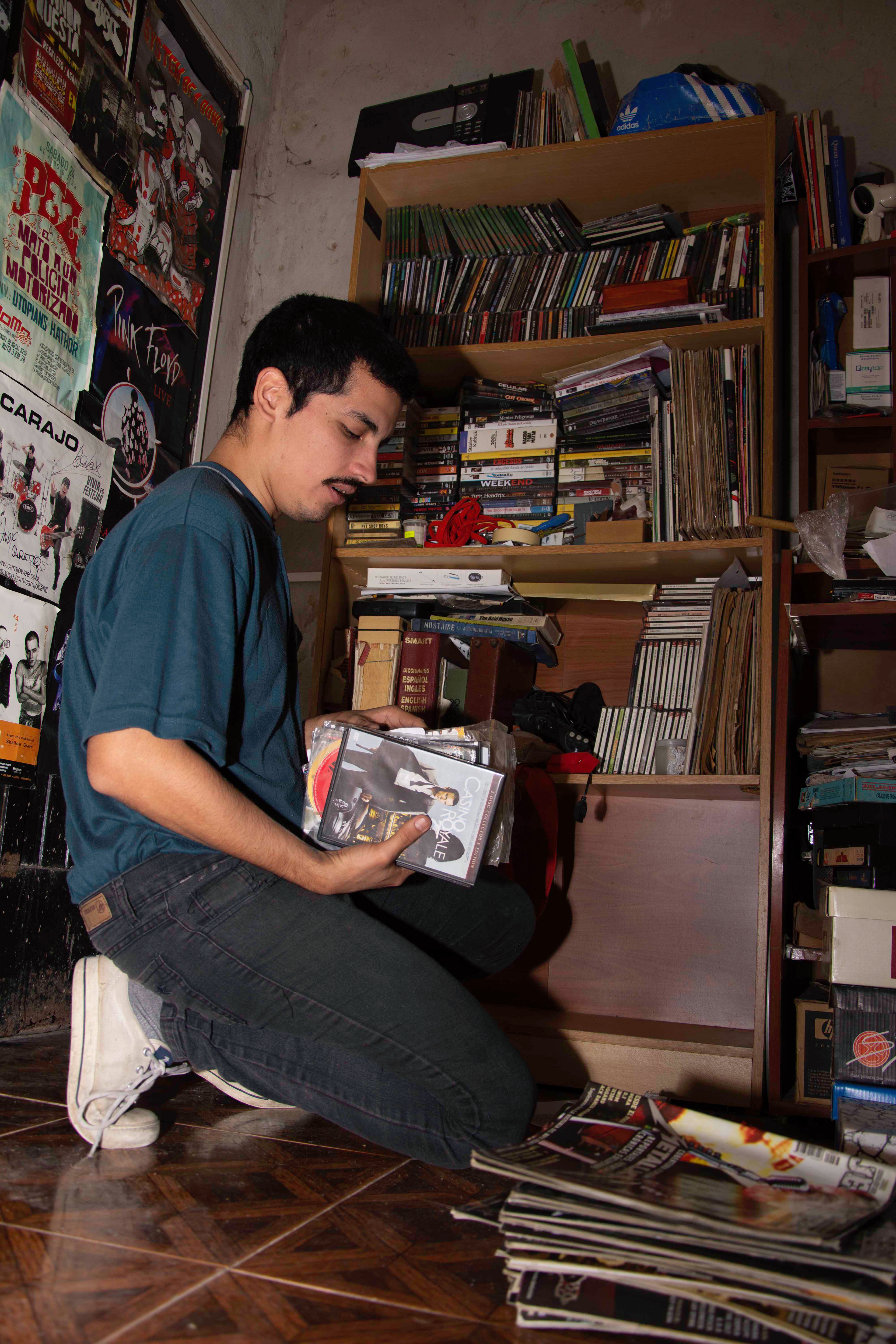 Rodrigo ordena sus libros, discos y películas en un mueble. 08/04/2019, Isidro Casanova, Buenos Aires, Argentina Foto: Luciano Cericchio/ Argra Escuela