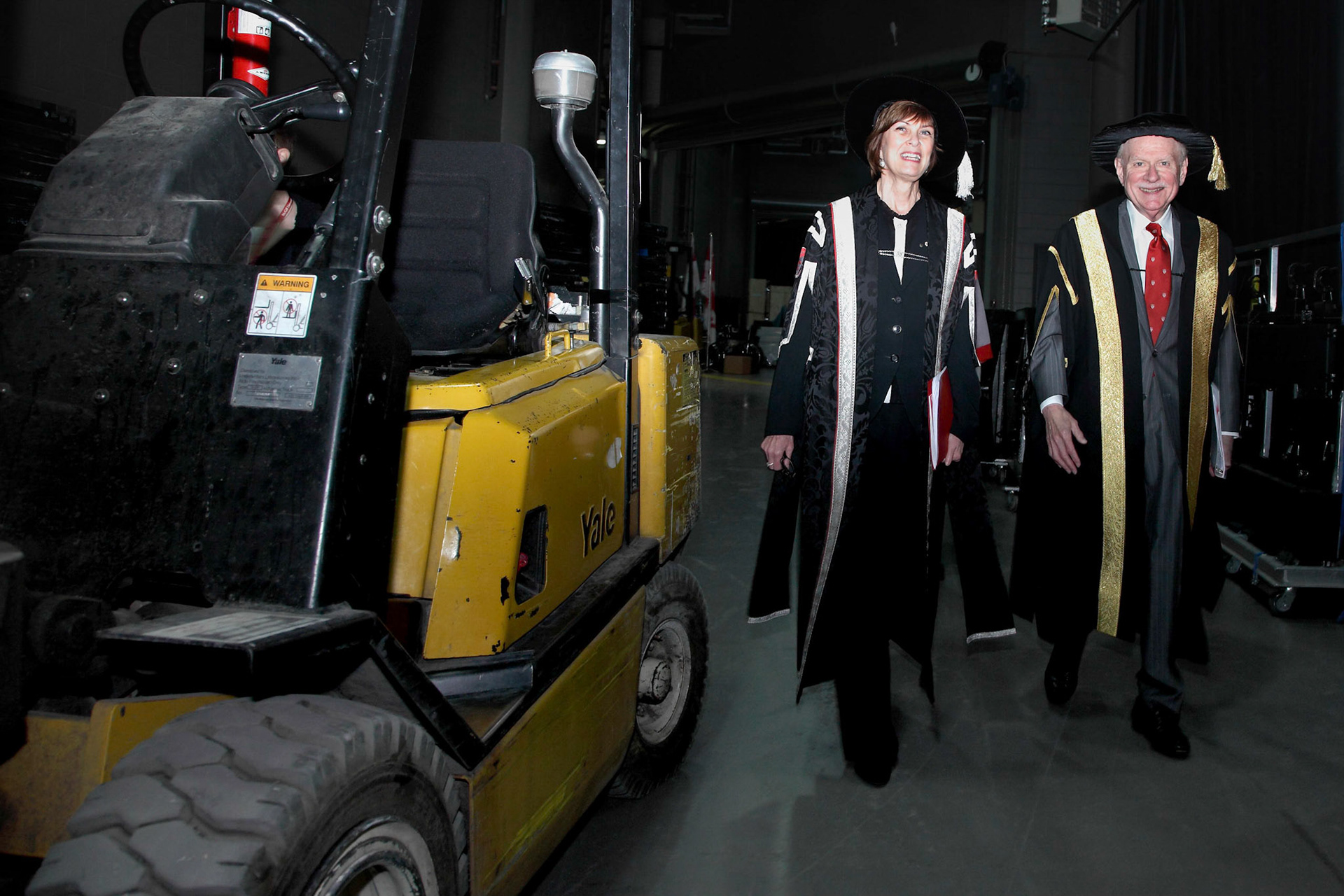 A forklift deftly dodged, Principal Heather Monroe-Blum and Chancellor Arnold Steinberg proceed towards the Convocation stage at the Bell Centre.  June, 2012.