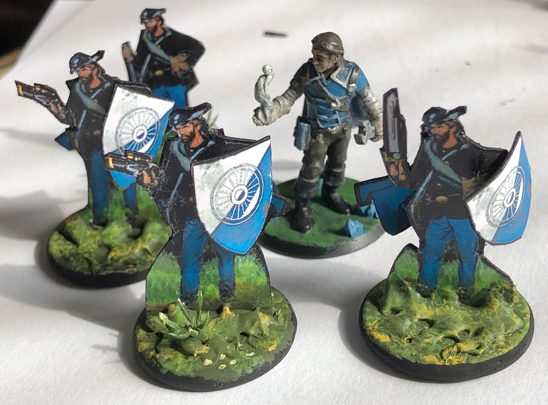 Assembled with hot glue to give dimesionality, these paper figures fit in with standard gaming miniatures.