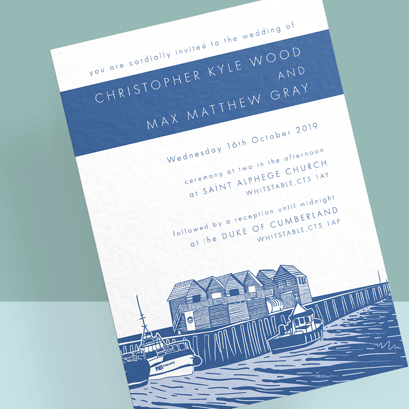 This image shows Inky Acorn Designs' invitation design featuring Whitstable Harbour in Kent. The fishermen huts and boats moored in the harbour are a key part of the illustration. The colours used are primarily blues and it is created in Inky Acorn Design's relief print style. The text on the wedding invitation is in a thin sans serif font and aligned to the left of the invitation. The names of the couple are in a blue banner near to the top of the page in the same blue as is in the drawing.