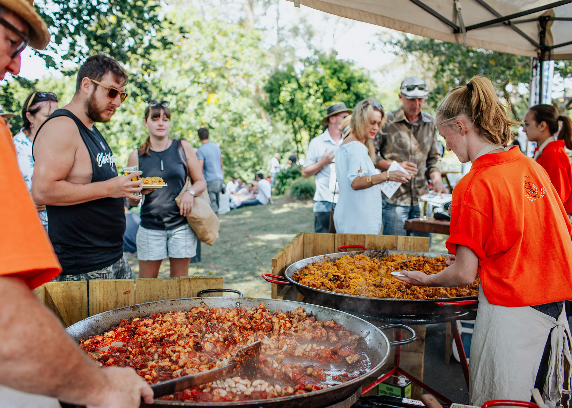 Paella being cooked and served to customers