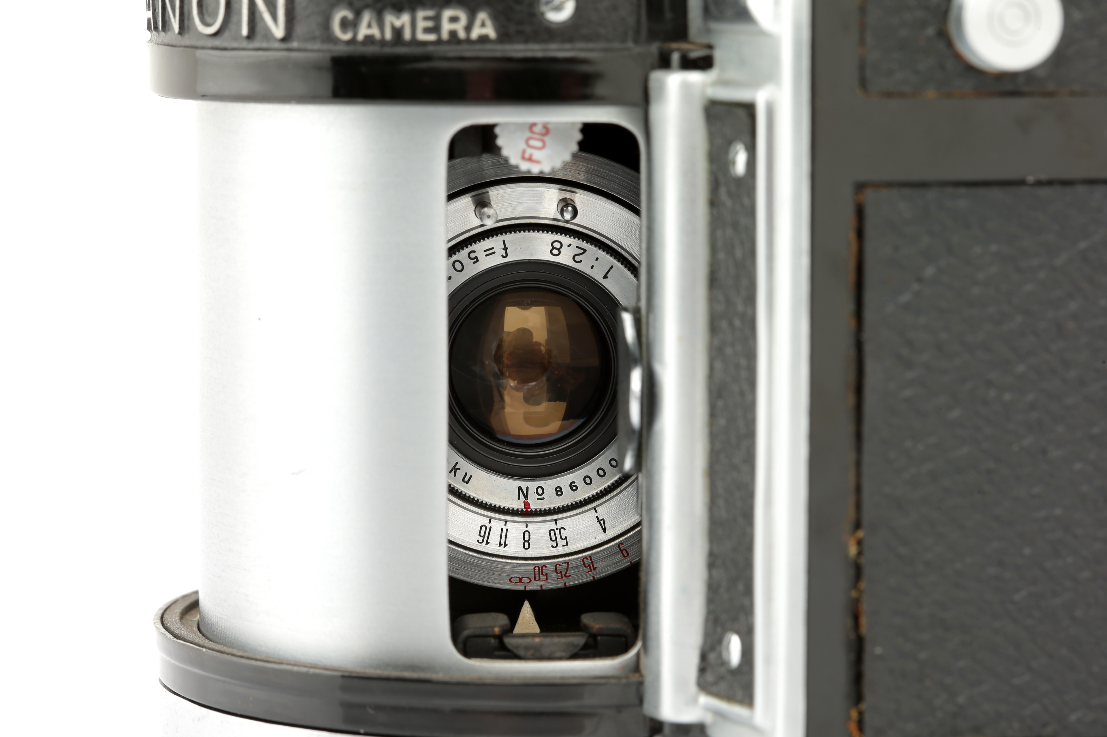 A close-up of the lens slit of a Panon Wide Angle camera, you can set aperture and focus using little wheels within the lens housing, via the slit.