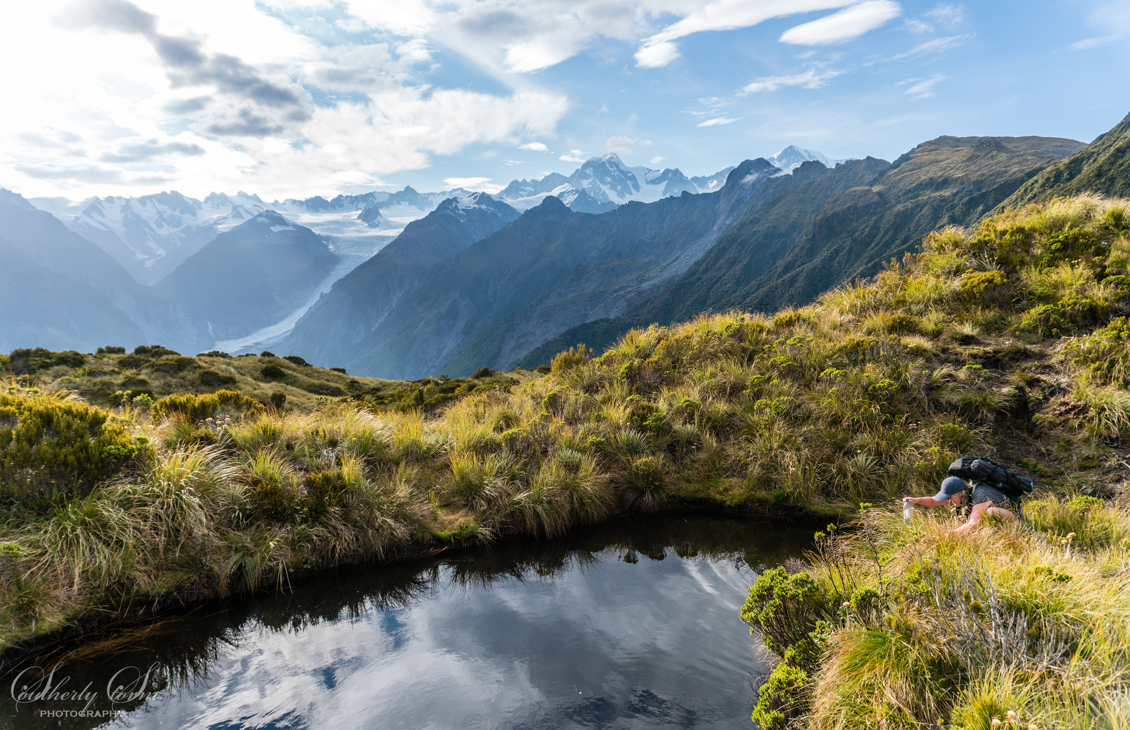 Hiker in front of Fox glacier, Mt Tasman and Aoraki