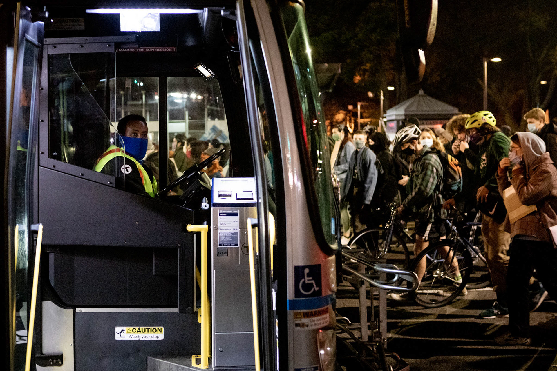 Protesters hold up a silver line bus on Massachusetts Avenue as they walk to Copley Square.