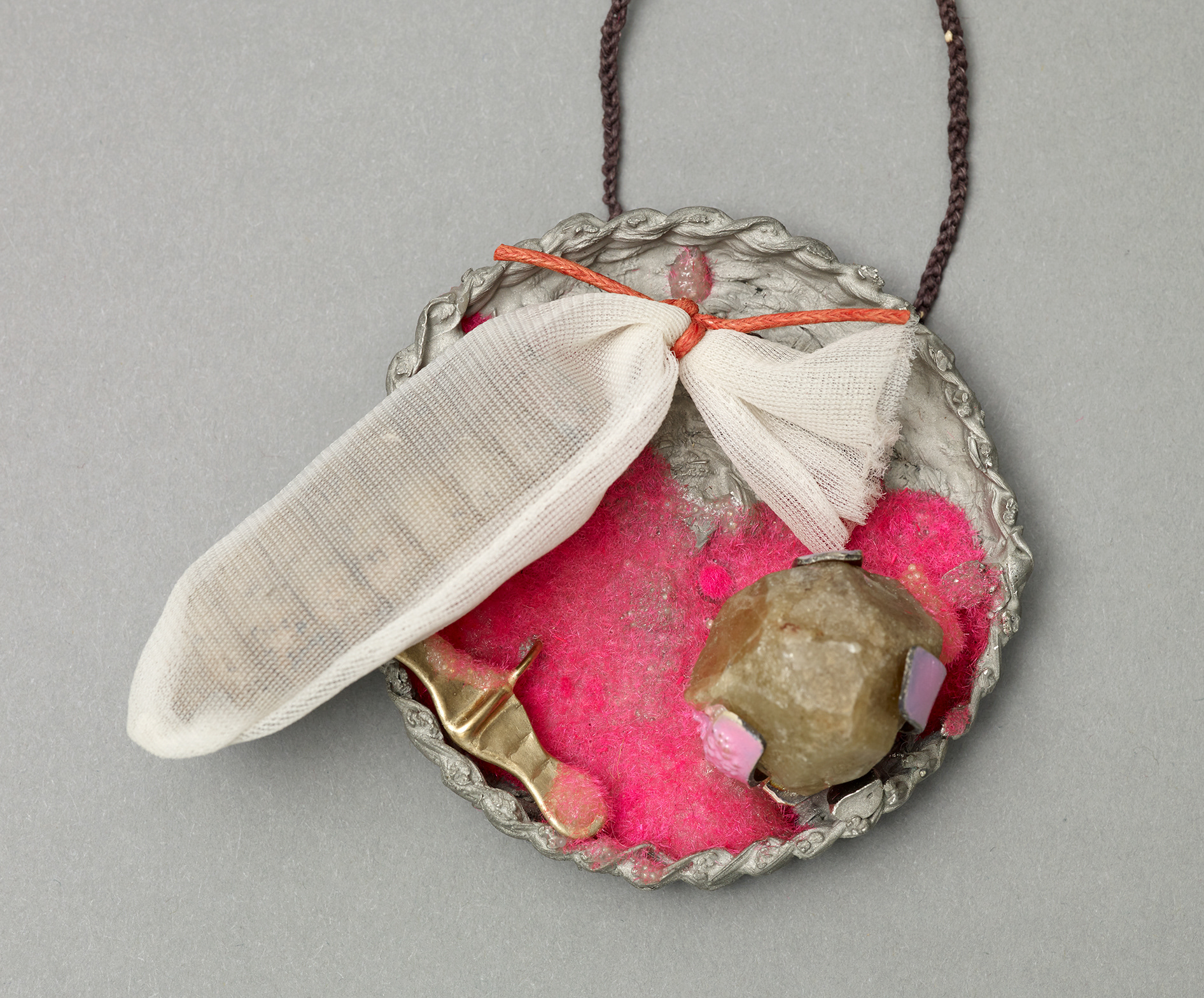 No.9 Item: Pendent H 42cm W 8cm D 3cm Materials: rattle from snake, gold, silver, pewter, green garnet, flocking, finger from glove, military waxed tread, porcelain, nail varnish. Photo credit: Michael Pollard