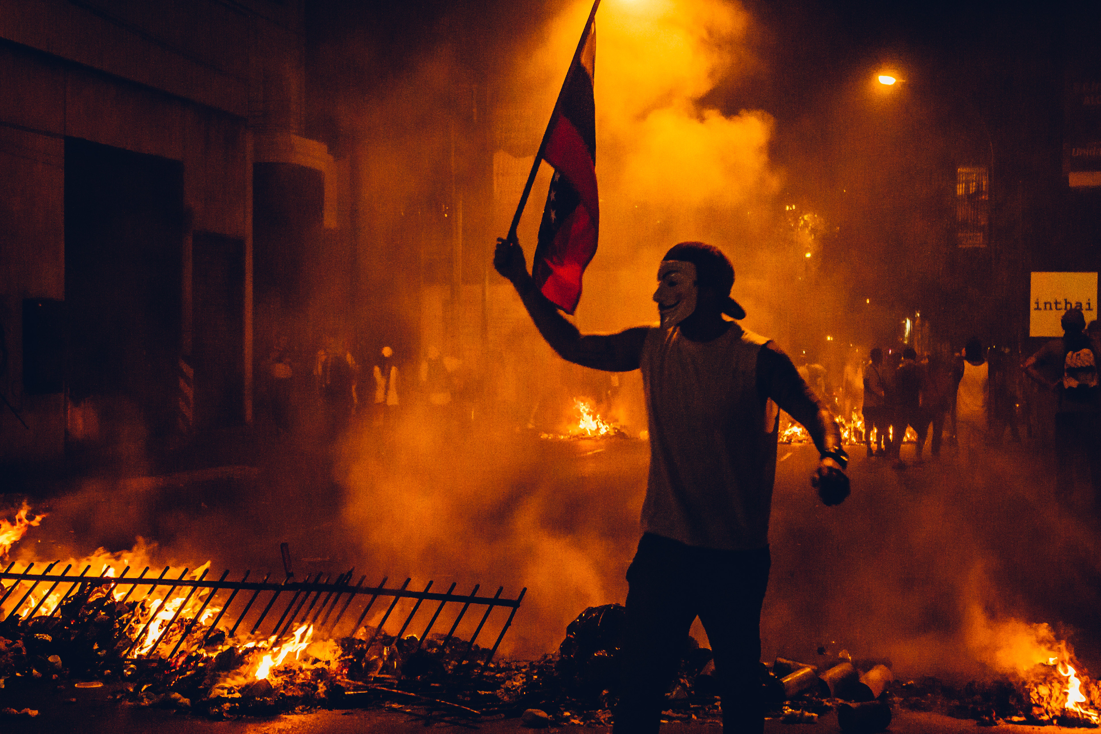 A protester calling others to help on the front line over a barricaded street during the first week of protests in February 2014. Caracas