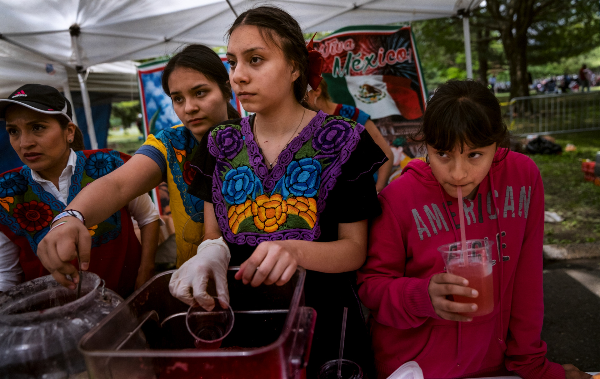 Hillary, center, and Julisa Garcia, center left, along with their sister Nicole and a family friend, help their mother to sell food at a Mother’s day festival in Queens. May 2017.