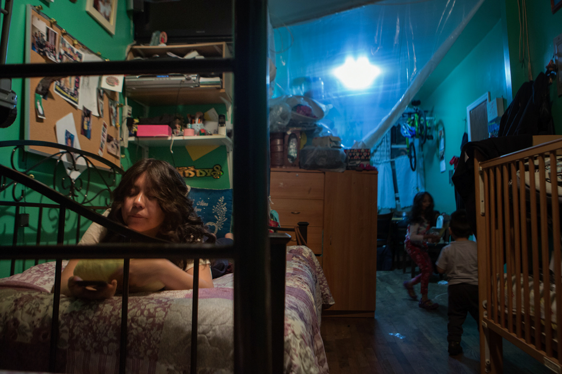 Joscelyn Valdez, 16, watching videos on her phone in her bedroom. Brooklyn. March 2017.
