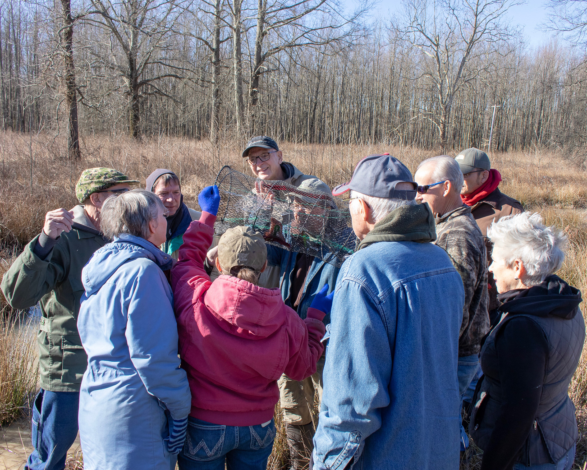A group of Indiana Master Naturalists examine a frog trap in hopes of finding the endangered crawfish frog. The more common leopard frog was found in this particular trap. It was released to go about its business.