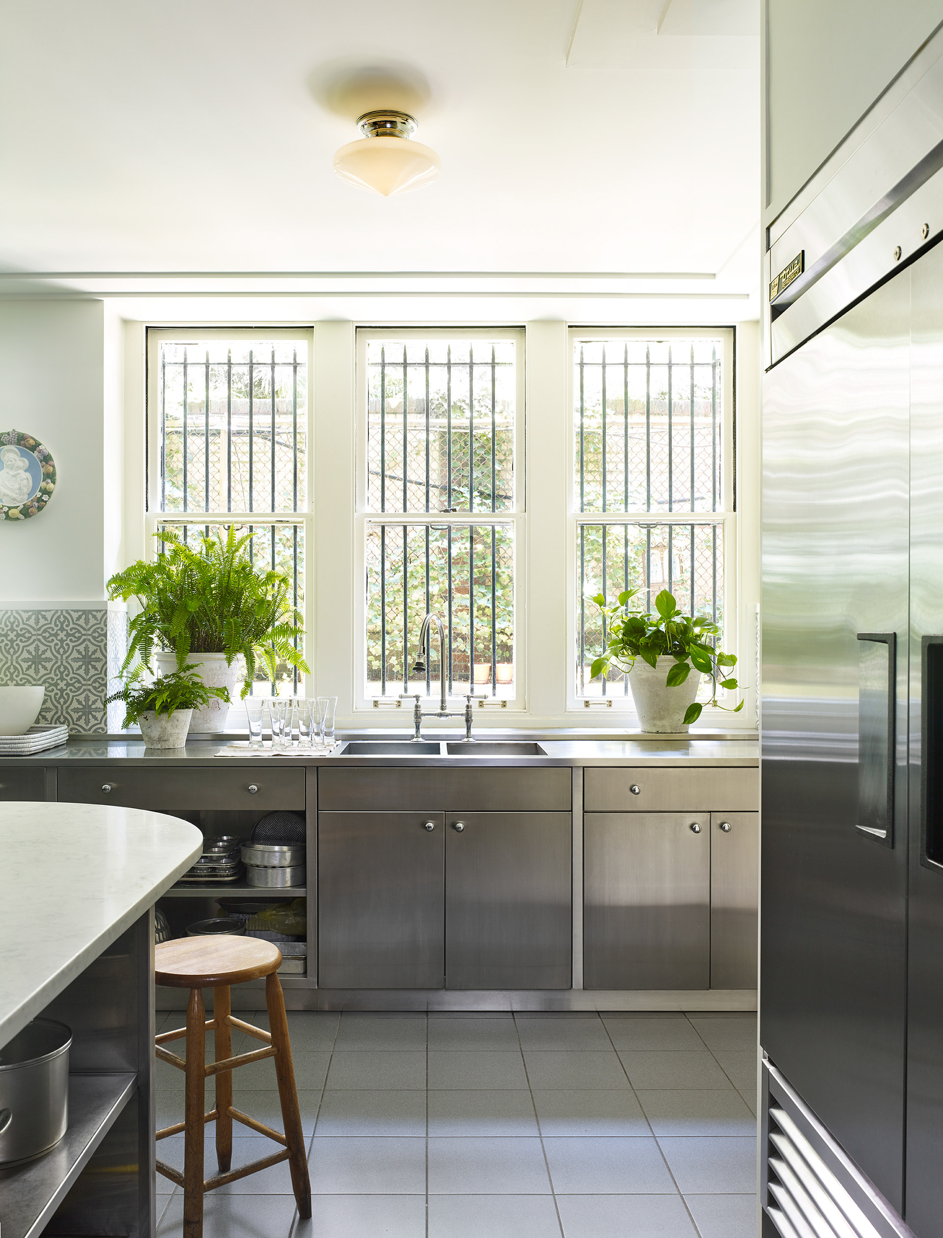 Kitchen with lots of windows, stainless steel lower cabinets, and porcelain tile floor.