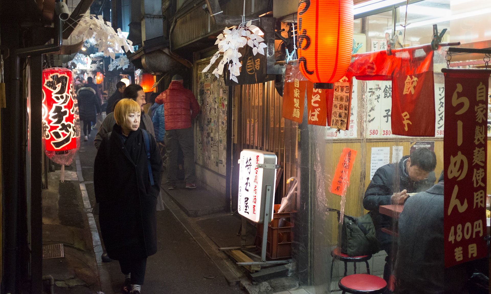 Woman checking out the various Izakaya pubs in Piss Alley, aka Omoide Yokocho or Shomben Yokocho