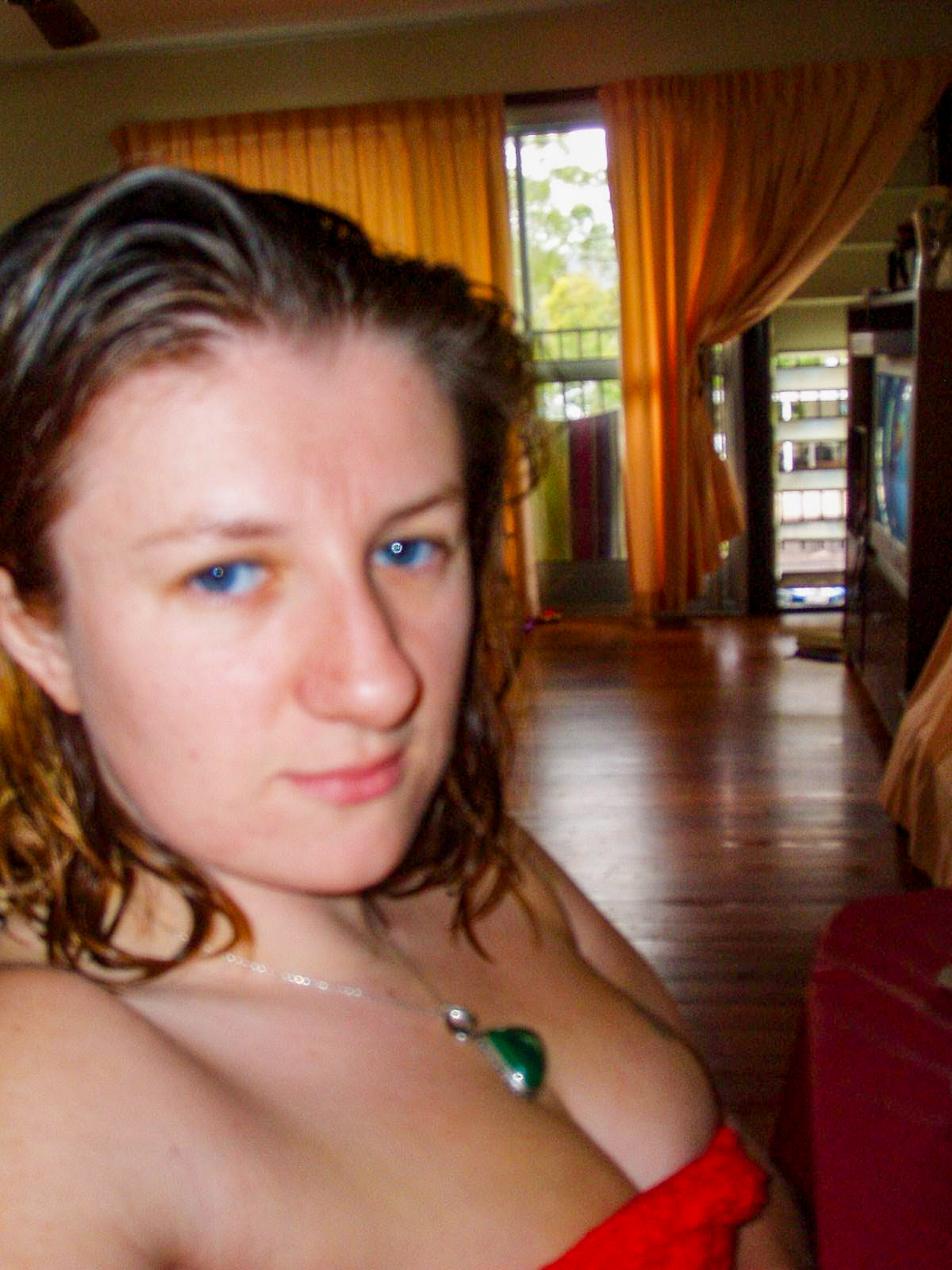 A close up of Malissa as a woman, wearing little clothing, with wet hair and a slight smile