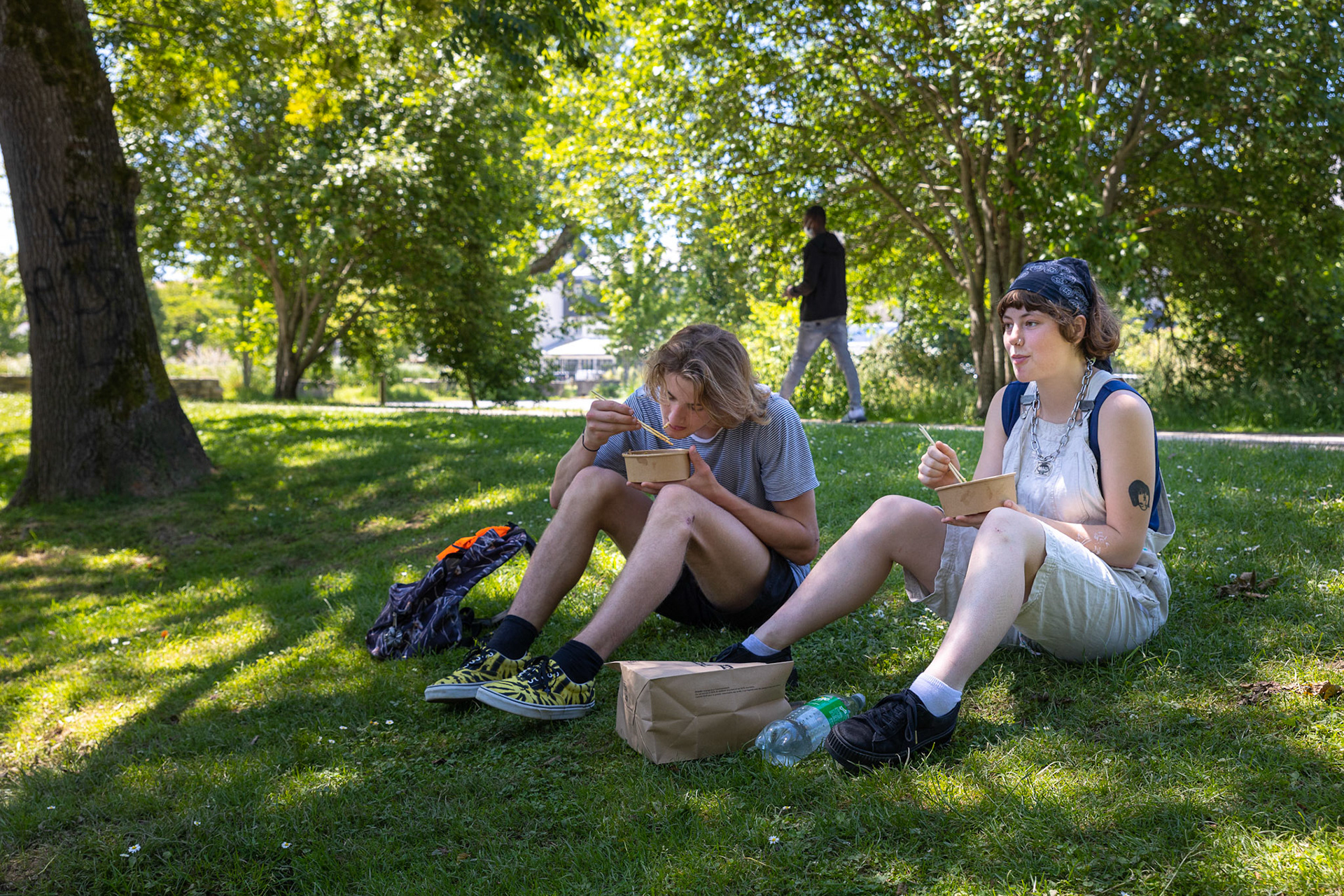 Des jeunes déjeunent dans les espaces verts du parking de la Providence.
