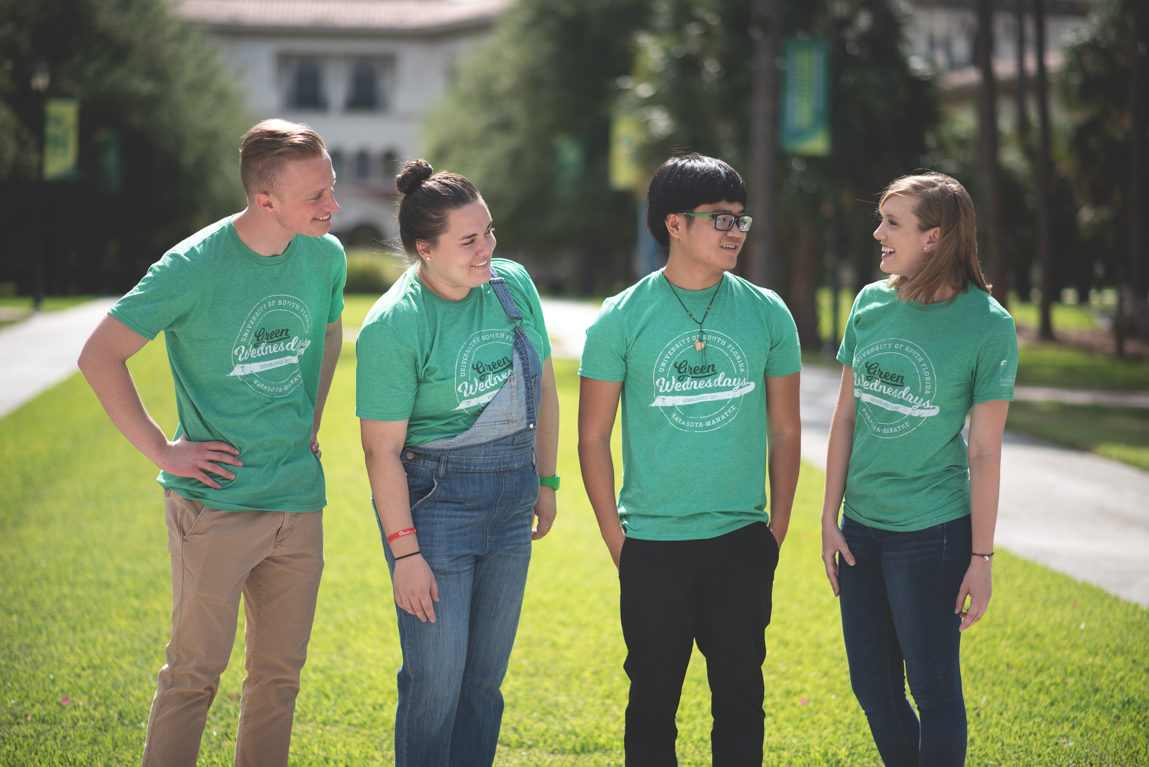 University t-shirt logo design for "Green Wednesdays," worn by four students