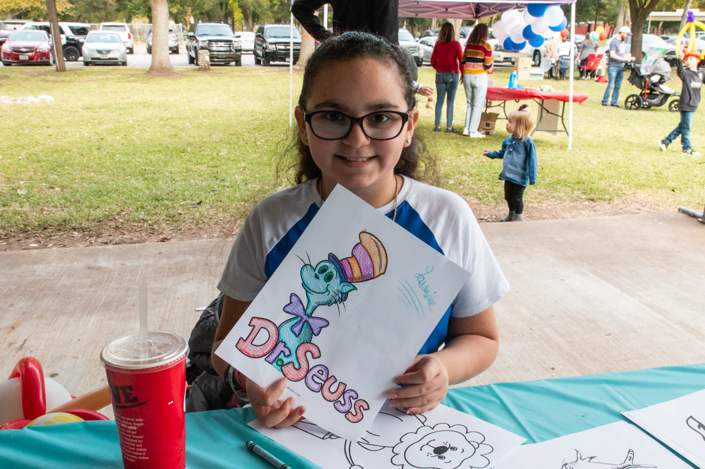 Jasmine Reyes, age 10, from Freeport poses with the picture that she colored at the art table at the Teddy Bear Carnival on November 17, 2019.
