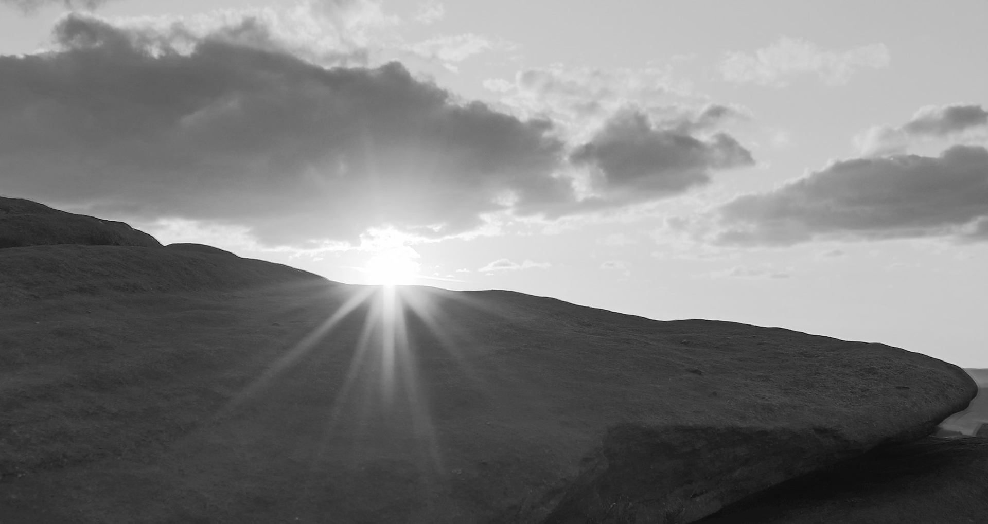 The sun setting behind the millstone grit rocks on Stanage Edge