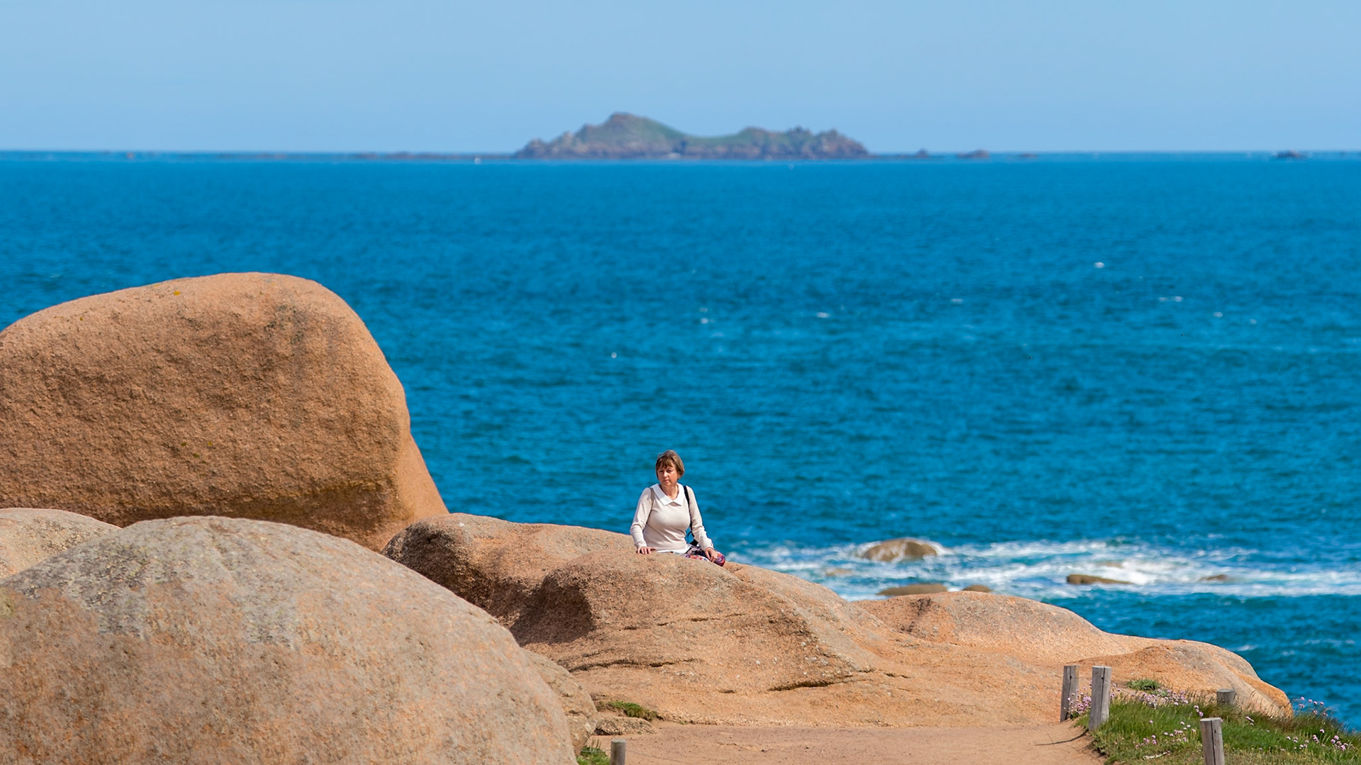 My wife and muze in a lorelei-like pose amidst the pink granite of Brittany, France..
