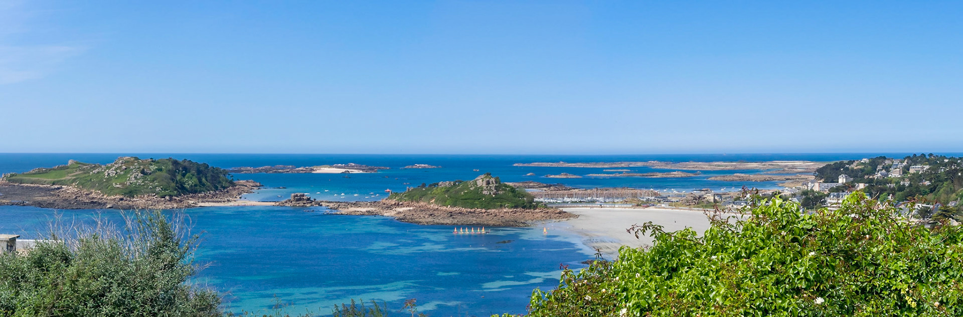 The bay of Trébeurden seen from Pointe de Bihit. Wonderful blue ocean, a line of small sailing boats, vacation!
