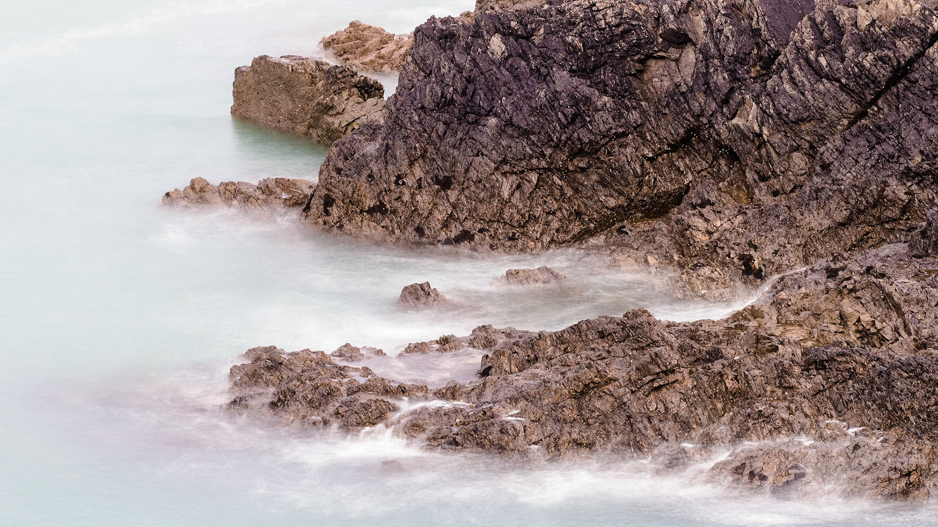 Hi-res with long exposure rendering the waves smooth, while revealing texture in the rocks