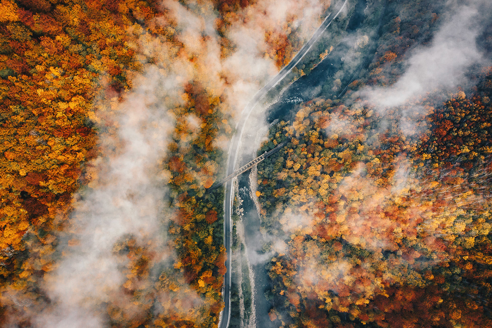Autumn foggy road and railway aerial view