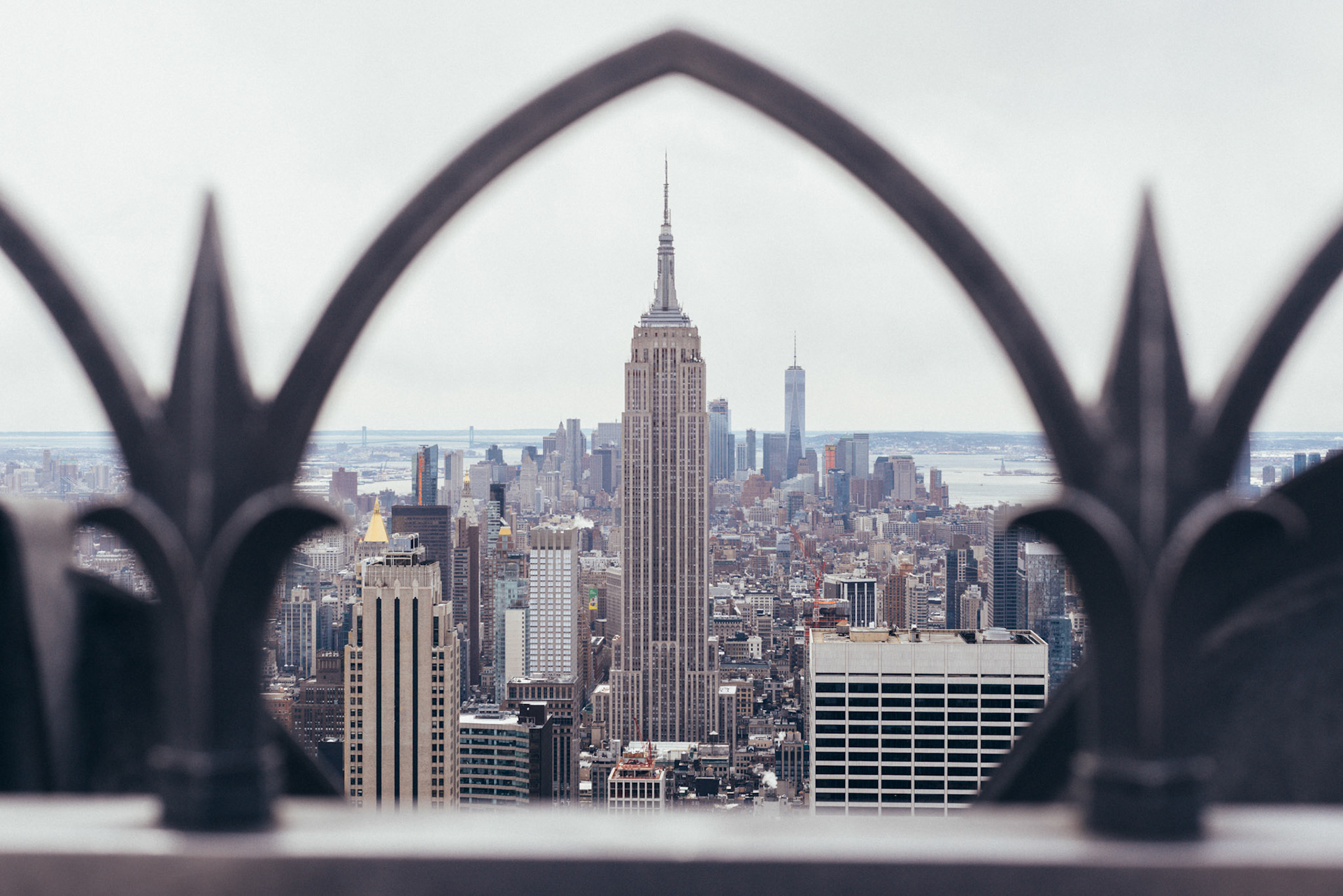 Railing at Top of the Rock frames the Empire State Building.