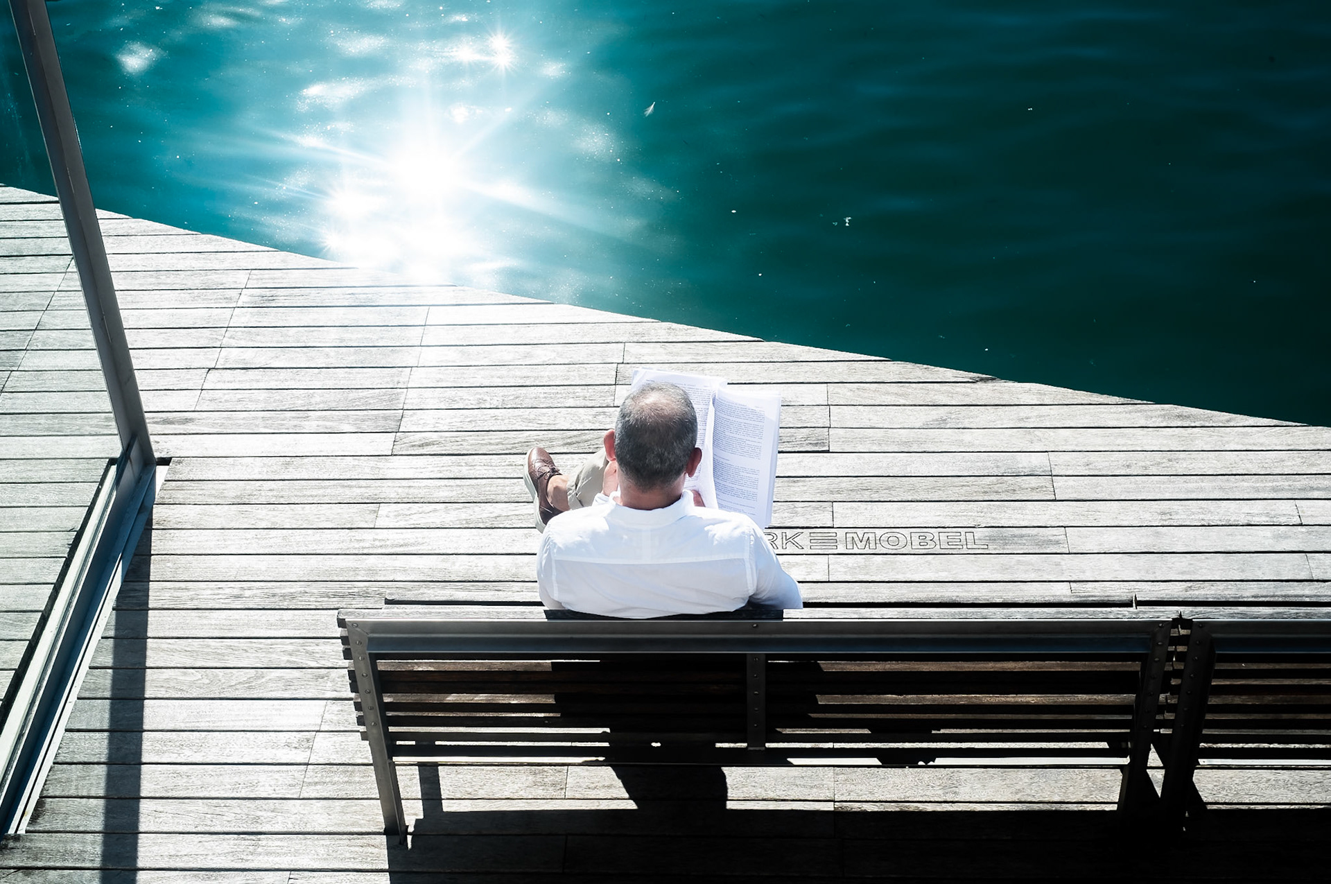 Man reading on pontoon - Lifestyle Photography